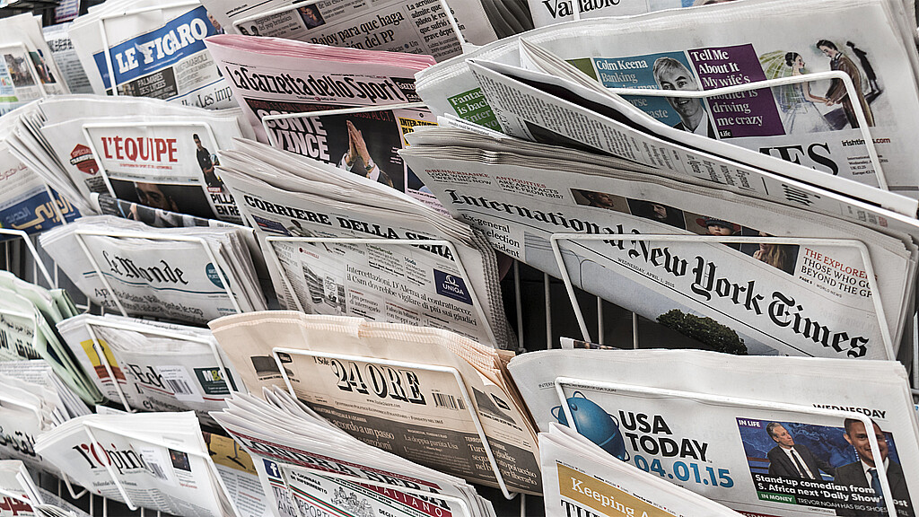 A London newspaper rack holding several international newspapers
